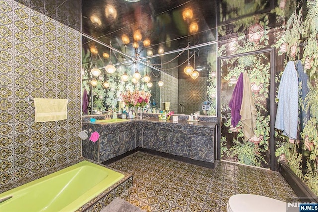full bath featuring a bath, vanity, and toilet