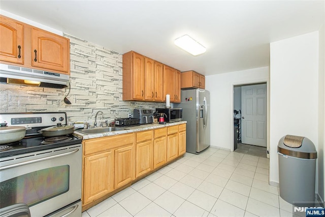 kitchen with under cabinet range hood, stainless steel appliances, light countertops, a sink, and decorative backsplash