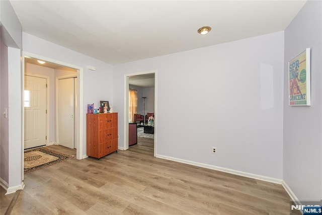 empty room featuring light wood-style flooring and baseboards