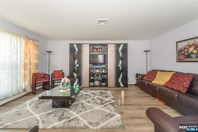 living area featuring a baseboard radiator, wood finished floors, and visible vents