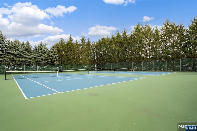 view of tennis court featuring fence and community basketball court