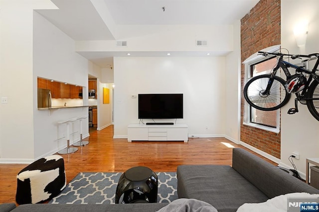 living area with light wood-style flooring and baseboards