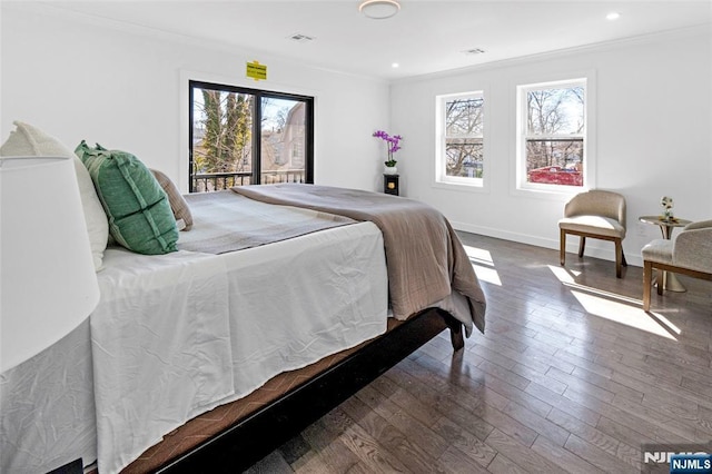 bedroom with dark wood-style flooring, ornamental molding, multiple windows, and baseboards