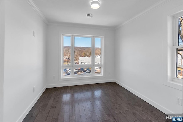 spare room featuring ornamental molding, baseboards, dark wood-style flooring, and visible vents