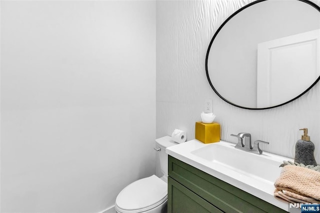 half bathroom with toilet and vanity
