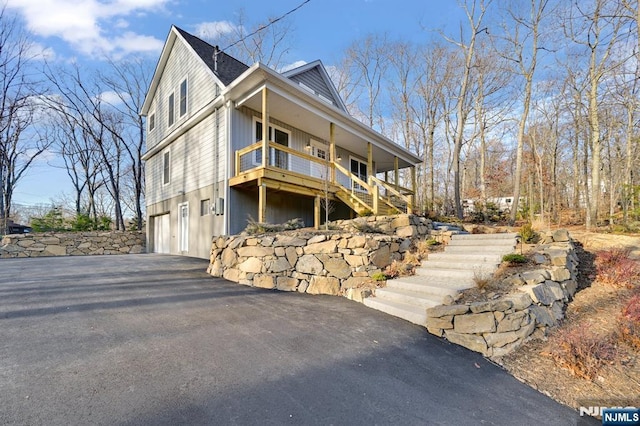 305 Mountainside Dr, Vernon, NJ 07422 - view of side of property with stairs, asphalt driveway, an attached garage, and a porch