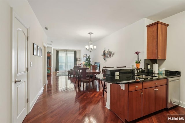 kitchen with dark wood-style flooring, visible vents, a sink, a peninsula, and a chandelier