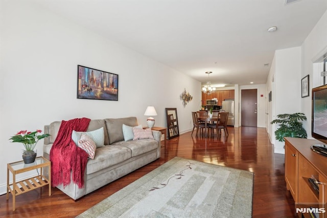 living area with dark wood-style floors and a notable chandelier