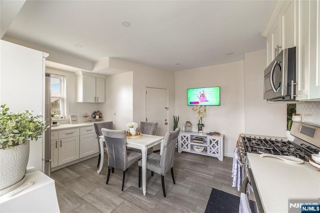 61 Sabina St, Little Ferry, NJ 07643 - kitchen featuring backsplash, light wood-style flooring, stainless steel appliances, and light countertops