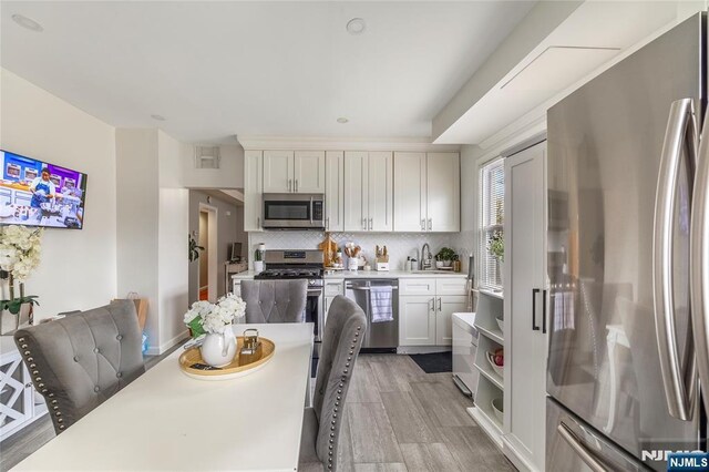 61 Sabina St, Little Ferry, NJ 07643 - kitchen featuring tasteful backsplash, a sink, stainless steel appliances, light countertops, and white cabinets