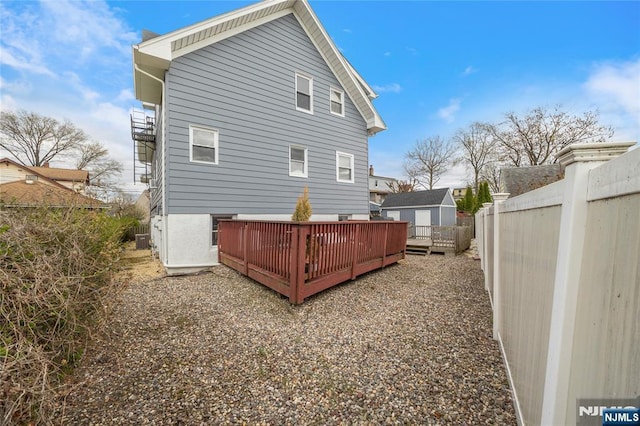 61 Sabina St, Little Ferry, NJ 07643 - back of property featuring fence, central air condition unit, and a deck
