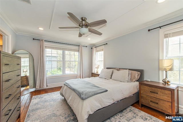 bedroom with crown molding, recessed lighting, multiple windows, and wood finished floors