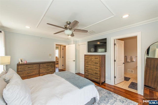 bedroom featuring ornamental molding, wood finished floors, and visible vents
