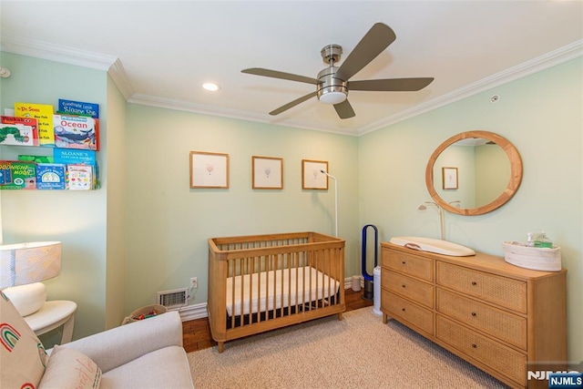 bedroom featuring crown molding, recessed lighting, a crib, and visible vents