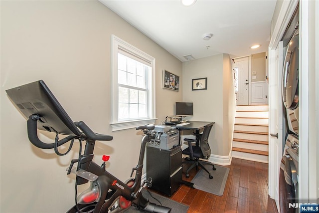 home office with recessed lighting, baseboards, dark wood-type flooring, visible vents, and stacked washer and clothes dryer