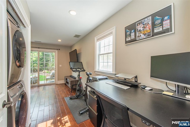 office area featuring stacked washer and dryer, visible vents, dark wood-style floors, and recessed lighting