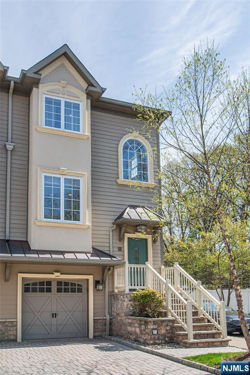 view of front of home featuring a garage, metal roof, a standing seam roof, and decorative driveway