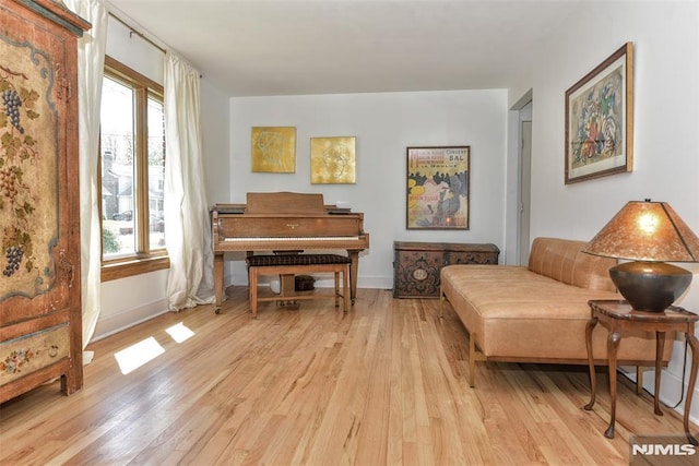 sitting room with baseboards and light wood-style floors