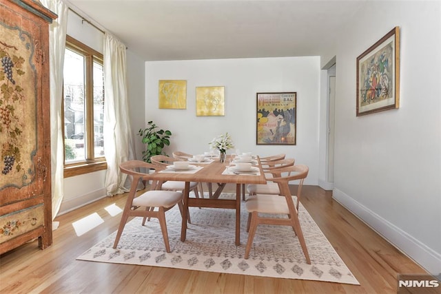 dining area featuring a healthy amount of sunlight, baseboards, and light wood-style flooring