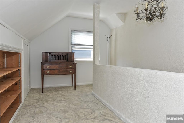 hall with baseboards, carpet, vaulted ceiling, and a notable chandelier