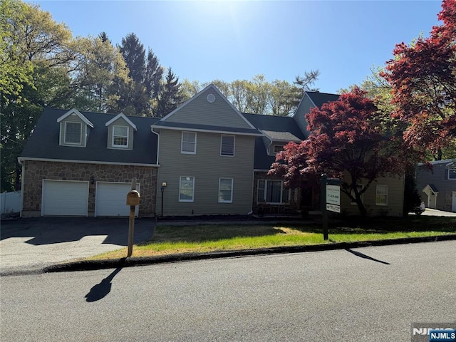 view of front of home featuring driveway and stone siding