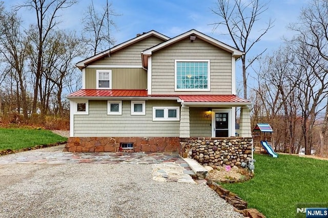 view of front of property with a front lawn, metal roof, and a playground