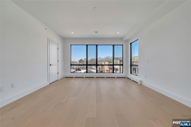 unfurnished room with recessed lighting, light wood-style floors, and baseboards