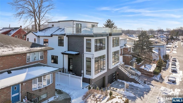view of front of house featuring a balcony, fence, a garage, stucco siding, and brick siding