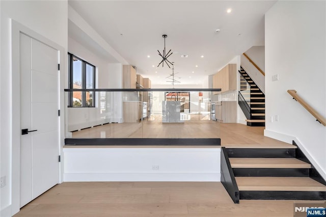 interior space with recessed lighting, wood finished floors, and an inviting chandelier