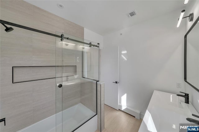 bathroom featuring baseboards, visible vents, enclosed tub / shower combo, and vanity