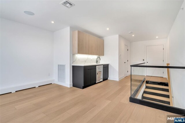kitchen featuring modern cabinets, light countertops, visible vents, and light wood-style floors
