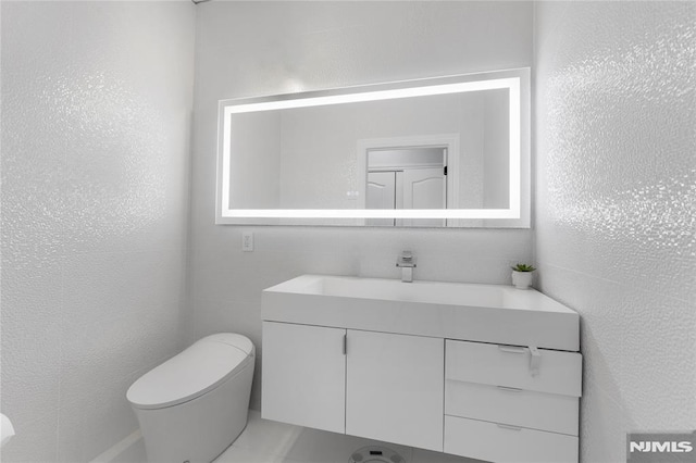 half bath featuring vanity and toilet