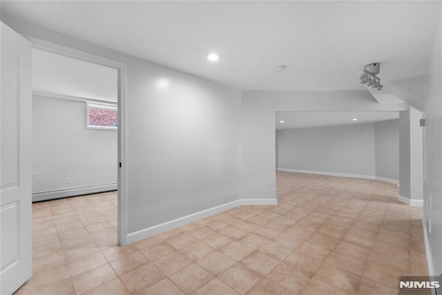 basement featuring recessed lighting, baseboards, and a baseboard heating unit