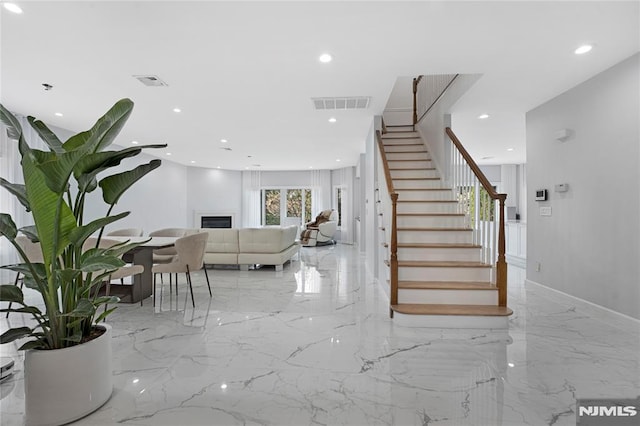 staircase with visible vents, recessed lighting, marble finish floor, and a fireplace
