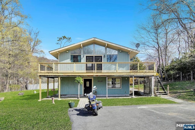 view of front of property featuring a front lawn, a deck, and stairs