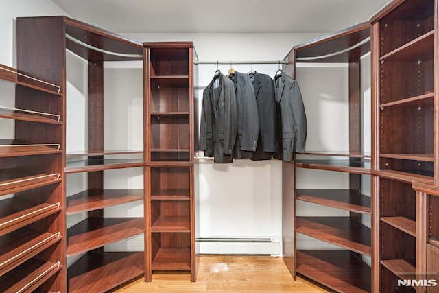 spacious closet with baseboard heating and wood finished floors