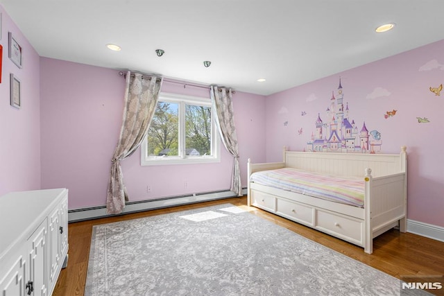 bedroom with baseboard heating, recessed lighting, and wood finished floors