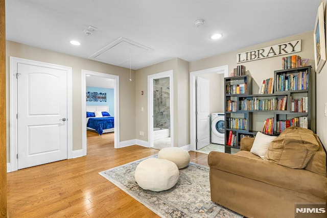 living area with baseboards, attic access, washer / clothes dryer, recessed lighting, and light wood finished floors