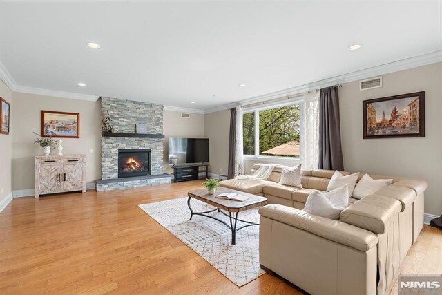 living room featuring visible vents, ornamental molding, recessed lighting, and light wood-type flooring