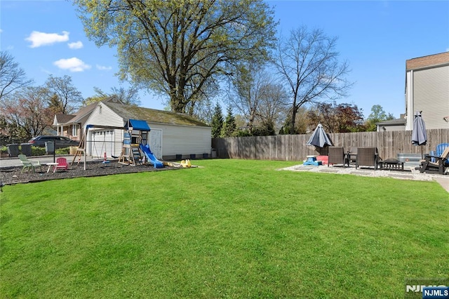 view of yard with a patio, a fenced backyard, and a playground