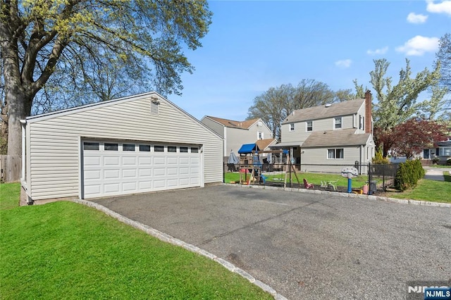detached garage featuring fence and a residential view