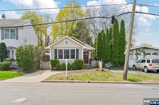 view of front of property with fence and an outbuilding