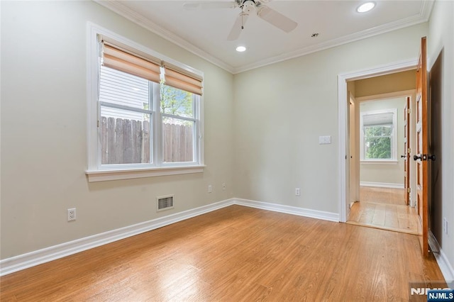 unfurnished room with ceiling fan, light wood finished floors, visible vents, and plenty of natural light