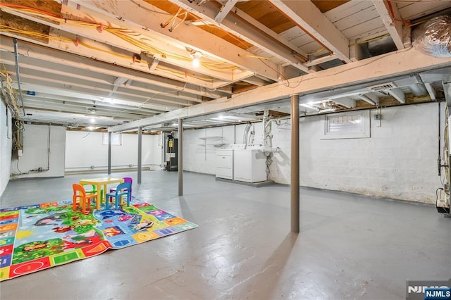 basement with water heater and washing machine and clothes dryer