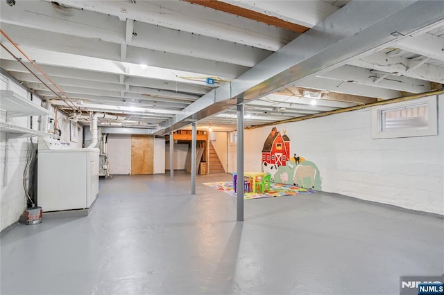 unfinished below grade area featuring washer / dryer and stairs