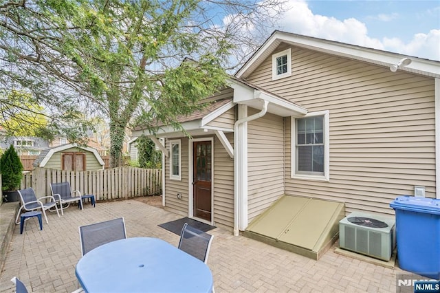 view of patio / terrace featuring central AC, fence, and outdoor dining space