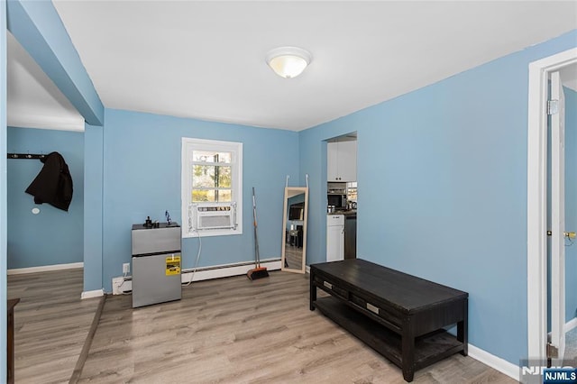 interior space featuring cooling unit, light wood finished floors, and baseboard heating