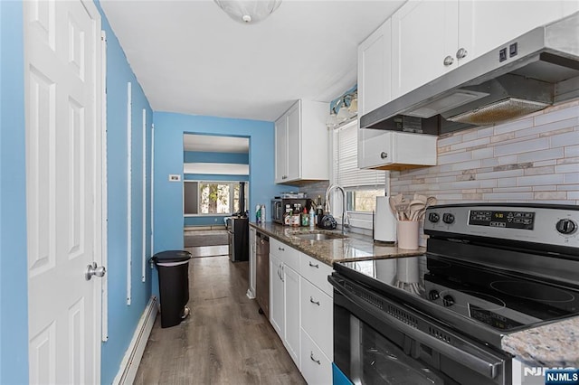 kitchen with stainless steel appliances, under cabinet range hood, baseboard heating, white cabinets, and a sink