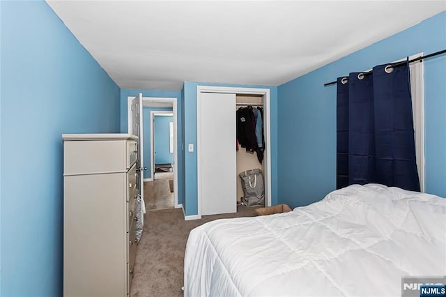 carpeted bedroom with baseboards and a closet