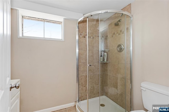 bathroom featuring toilet and a shower stall